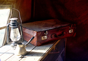 Still life with old leather suitcase and lamp