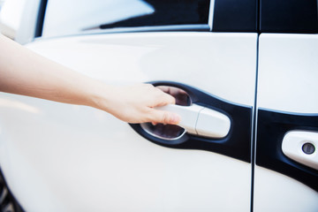 Hand of woman holding handle of car's door, to open car's door