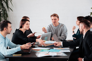 Top view of businessman executive in group meeting with other businessmen and businesswomen in modern office with laptop computer, coffee and document on table. People corporate business team concept.