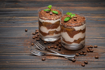 two portions Classic tiramisu dessert in a glass on wooden background