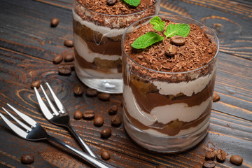 two portions Classic tiramisu dessert in a glass on wooden background