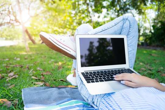 Closeup of young woman using laptop with relax in garden.