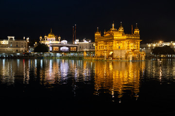 Fototapeta na wymiar Night view to the Golden temple (Harmandir sahib) with reflection in Amritsar, Punjab, India