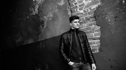 Portrait of the man standing in front of brick wall