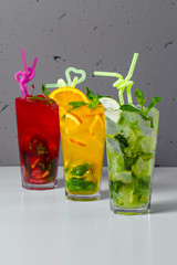 Three lemonade on the table on a background of gray concrete