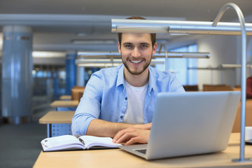 Portrait of young man sitting at his desk in the office.