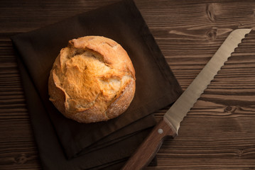 Loaf of wheat bread on wooden table