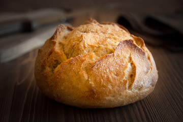 Loaf of wheat bread on wooden table
