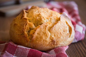 Loaf of wheat bread on wooden table