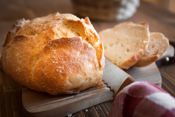 Sliced loaf of wheat bread on wooden table