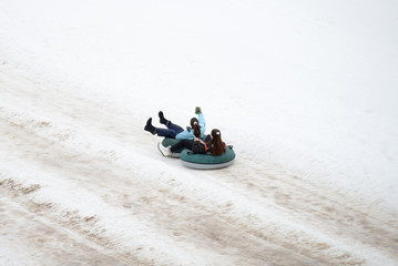 Two Girls Snow Tubing Together