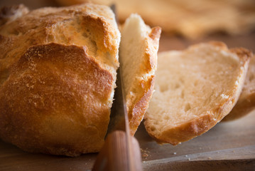 Sliced loaf of wheat bread on wooden table