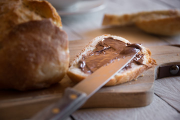 Sliced loaf of wheat bread with peanut butter for breakfast