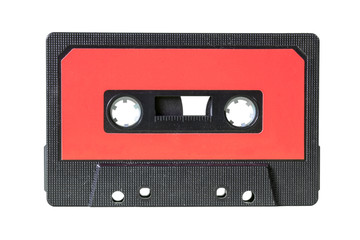 An old retro cassette tape from the 1980s (obsolete music technology). Black fine grid plastic body, red label.