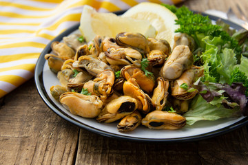 Peeled mussels with fresh lemom. Healthy seafood, natural sunlight, wooden rustic table.