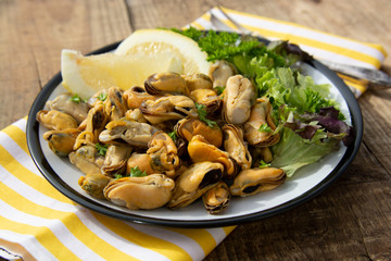 Peeled mussels with fresh lemom. Healthy seafood, natural sunlight, wooden rustic table.