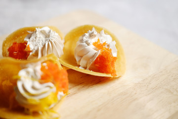 Thai Crispy Pancake (Kanom Buang) on wooden plate isolated on white background