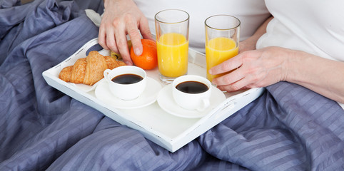  Couple enjoying one another while having breakfast in bed. 
