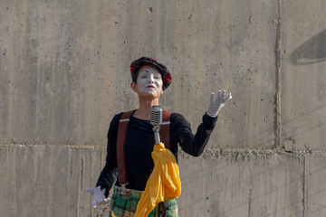 Mime on the street singing with microphone