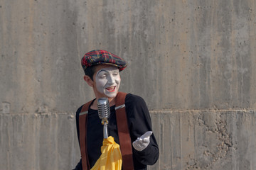 Mime on the street singing with microphone