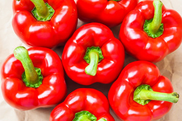 Bright red, fresh paprika on brown background, top view