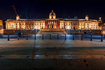 Fototapeta na wymiar Facade of the National Gallery and the Trafalgar Square in London (England) by Night