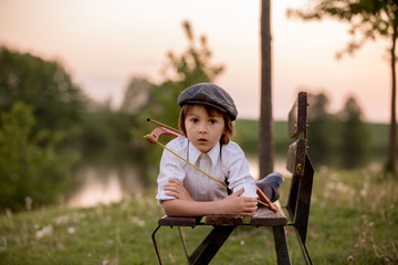 Portrait of child playing with bow and arrows, archery shoots a bow at the target.