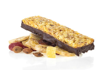 Granola bar on heap of dried fruits, seeds and nuts. White background. Concept of healthy food.