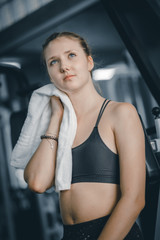 Fototapeta na wymiar Young attractive woman caucasian sitting and using towel to wipe the sweat. Relaxation after hard workout in gym. Fitness concept, Healthy, Sport, Lifestyle