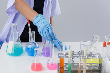 Cheerful  chemist woman in lap, or graduate student in lab coat ane protetive wear work,check and test chemistry.