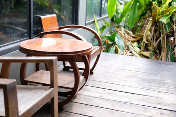 wooden table & chair on terrace near garden