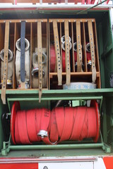 Feuerwehrschläuche aufgerollt in einem alten Feuerwehrauto