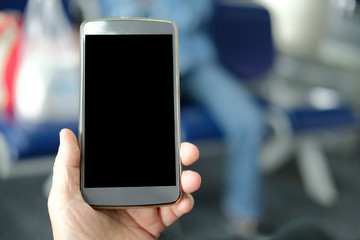 hand holding mobile smart phone at airport