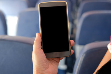 hand holding mobile smart phone on airplane