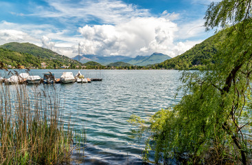 Obraz premium Landscape of lake Lugano and Swiss Alps in Lavena Ponte Tresa, province of Varese, Italy