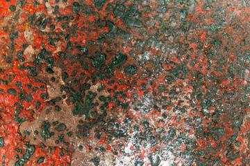 Red & green dried paint etched into concrete surface.