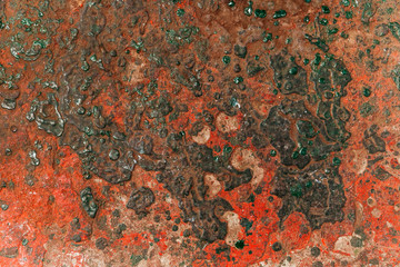 Green & red paint texture dried to sheet of metal.