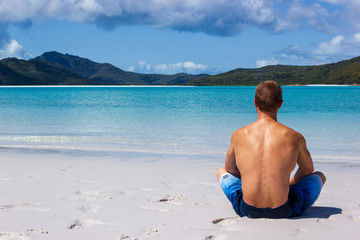 young man enyoing view over Whiteheaven beach on a beautiful sunny day with clouds, Whitsunday Island, Queensland, Australia