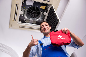 Obraz premium Young repairman repairing ceiling air conditioning unit 