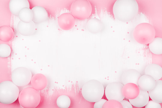Creative painted background with white pink balloons and confetti. Top view and flat lay. Birthday or party concept.