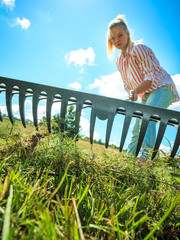 Unusual angle of woman raking leaves