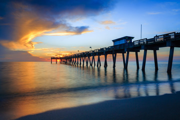 Fototapeta na wymiar Blurred water softens as the sun sets over Venice Pier in Florida