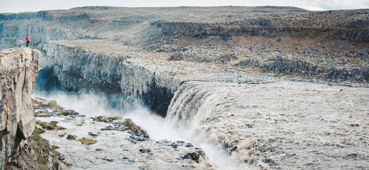 Hiker at gigantic Dettifoss waterfall in Iceland