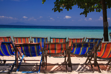 Group of isolated empty deck chairs on beach of Tropical Island with panoramic view on turquoise water, Ko Phi Phi, Andaman Sea, Thailand