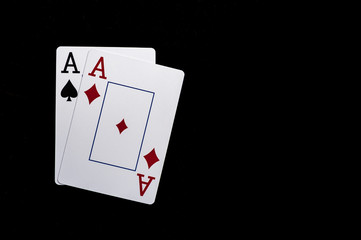 Two aces playing cards on black table