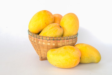 ripe mangos in a basker on a white background