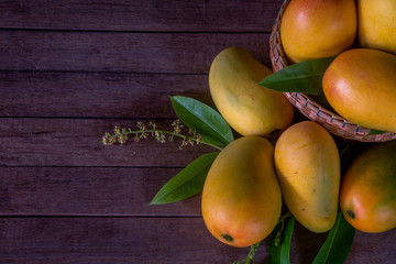 The ripe mango is in the basket on the wooden floor