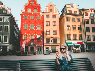 Woman tourist in Stockholm city Gamla Stan traveling lifestyle girl using smartphone blogging...