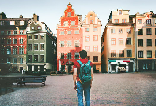 Man backpacker walking in Stockholm city travel sightseeing Stortorget architecture lifestyle summer trip vacations in Sweden