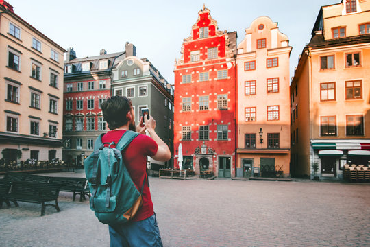 Man traveler walking in Stockholm city  travel lifestyle taking photo by smartphone  trip summer vacations